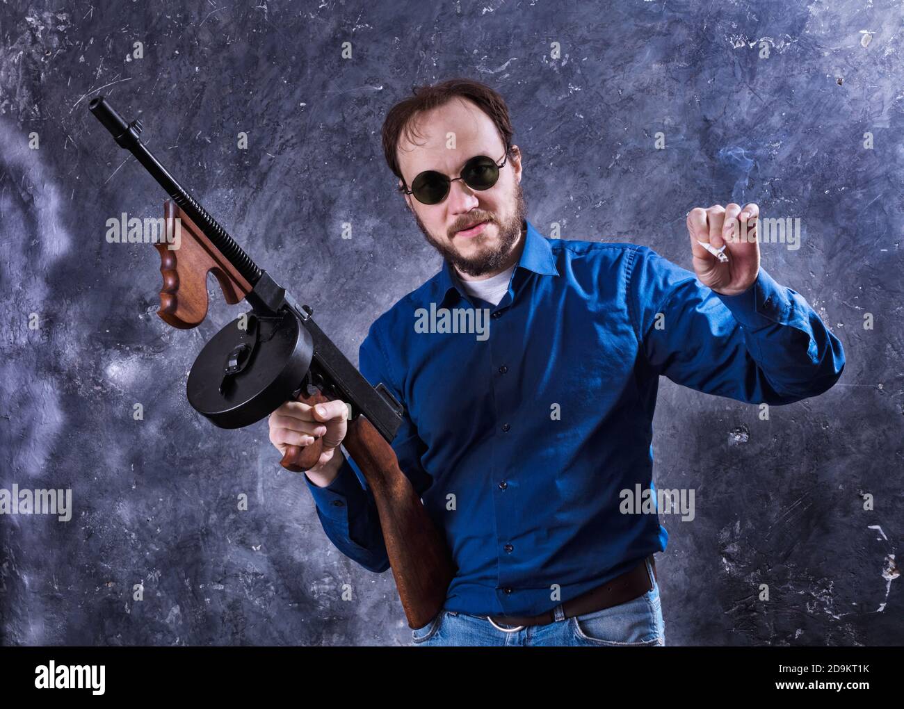 Homme mature en lunettes de soleil avec tommy Gun studio portrait Banque D'Images