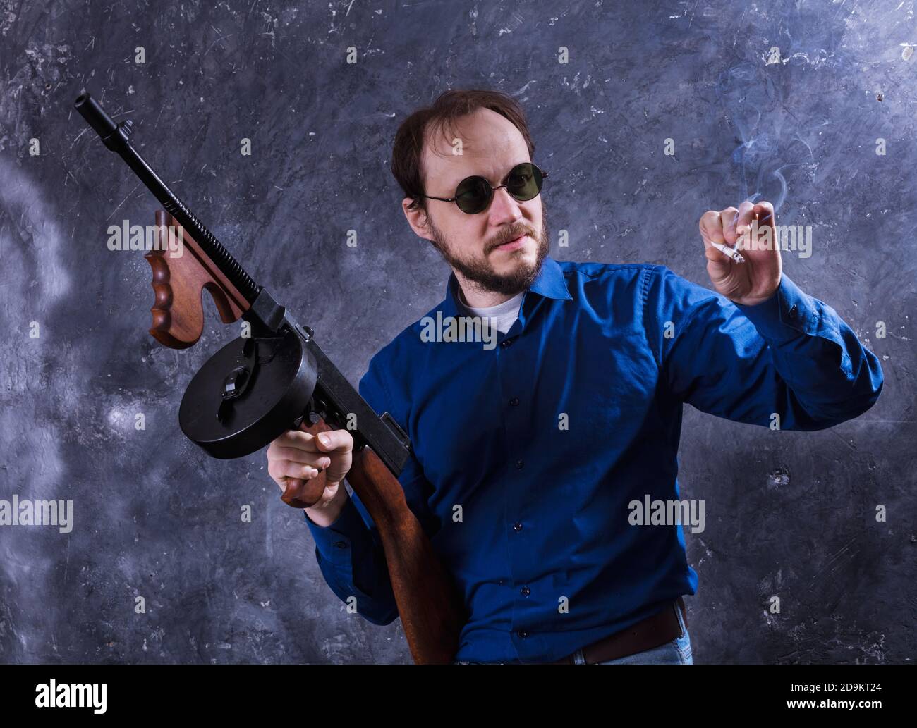 Homme mature en lunettes de soleil avec tommy Gun studio portrait Banque D'Images