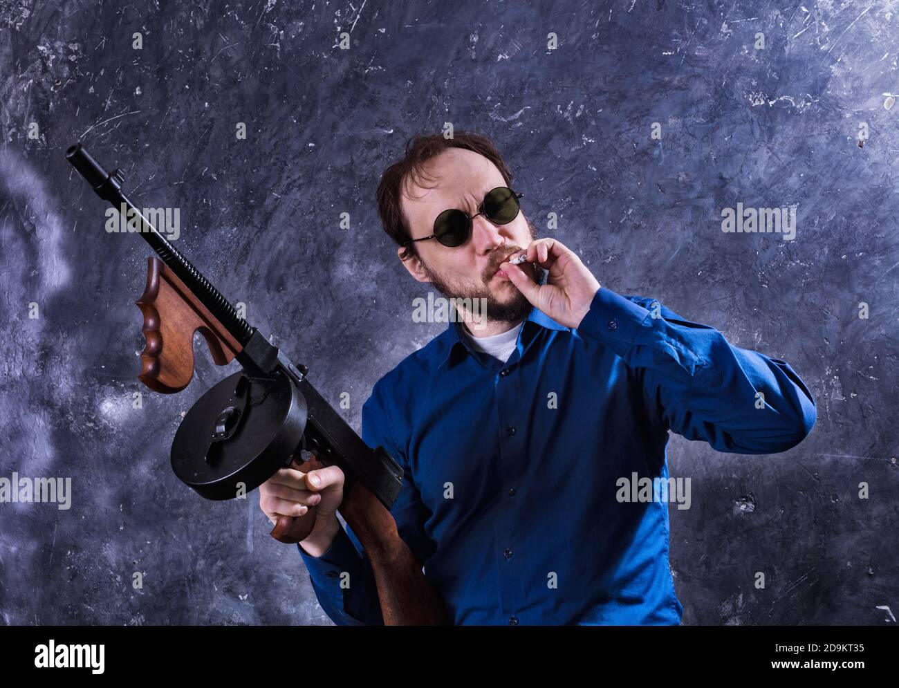 Homme mature en lunettes de soleil avec tommy Gun studio portrait Banque D'Images