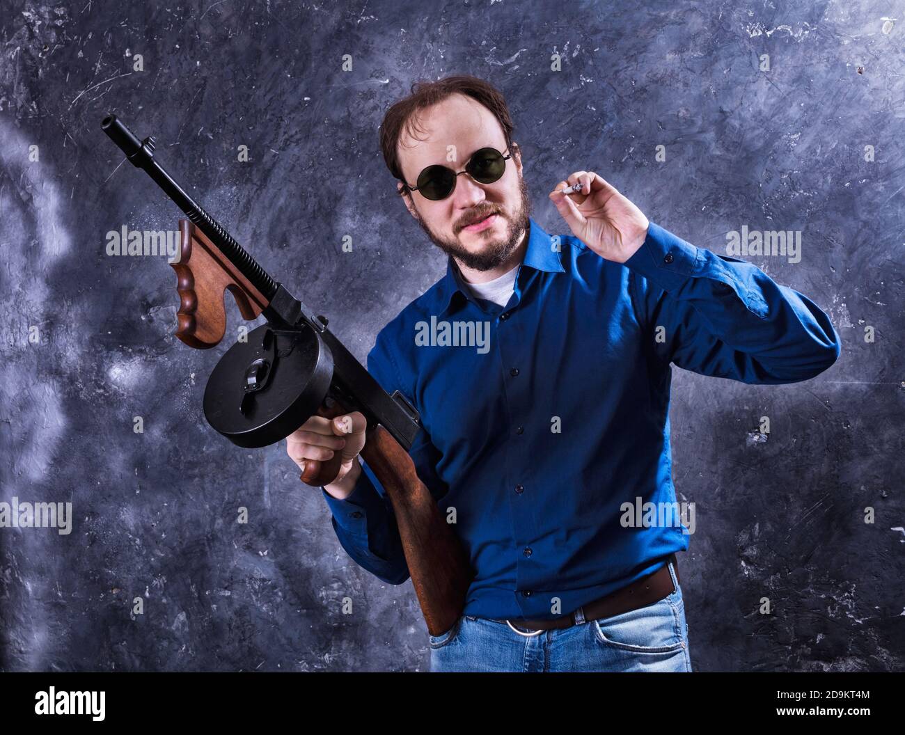 Homme mature en lunettes de soleil avec tommy Gun studio portrait Banque D'Images