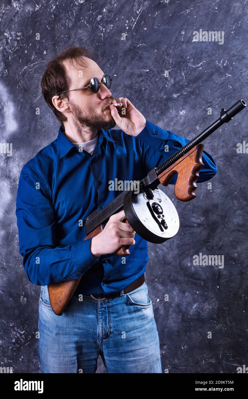 Homme mature en lunettes de soleil avec tommy Gun studio portrait Banque D'Images
