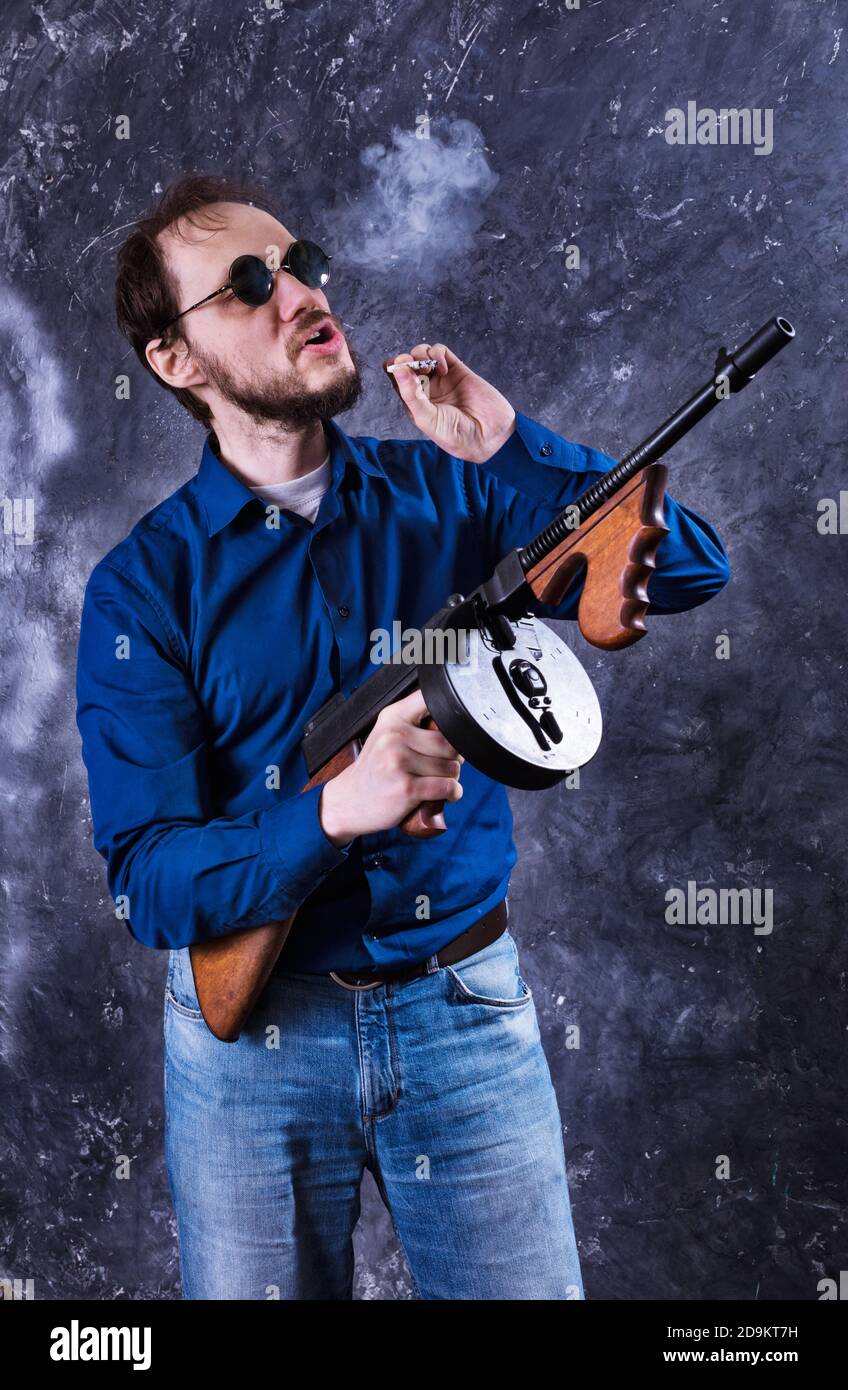 Homme mature en lunettes de soleil avec tommy Gun studio portrait Banque D'Images