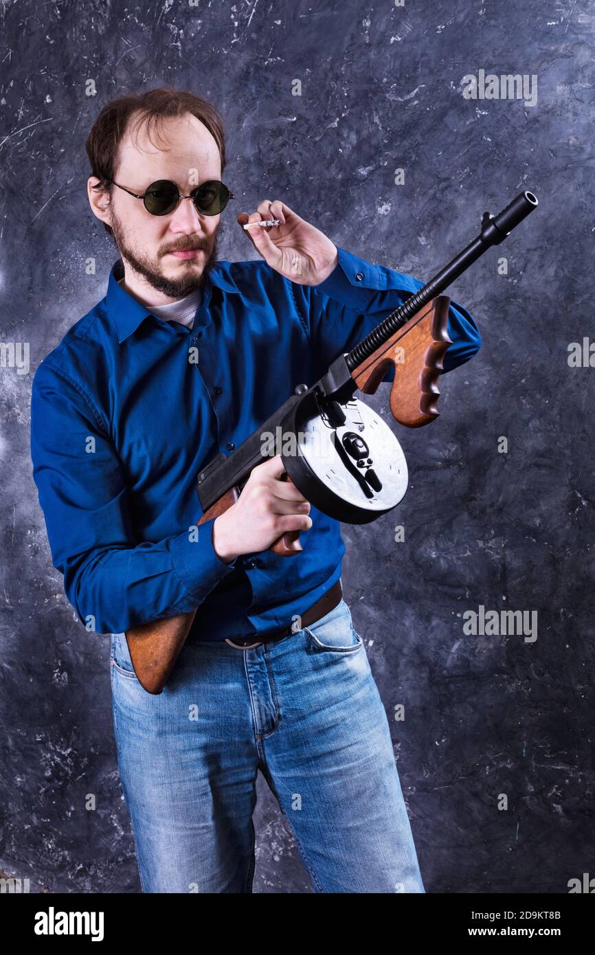Homme mature en lunettes de soleil avec tommy Gun studio portrait Banque D'Images