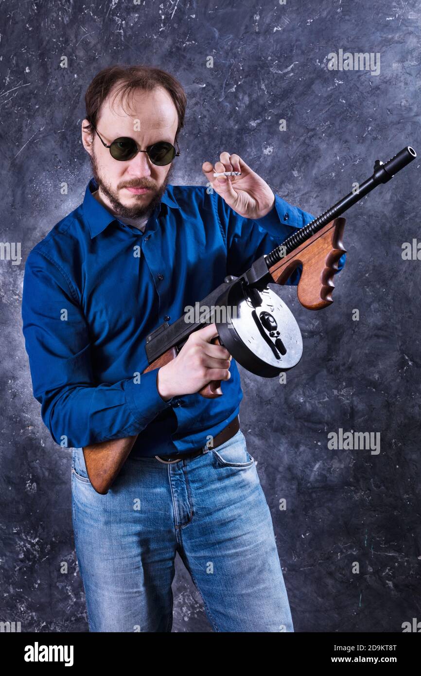 Homme mature en lunettes de soleil avec tommy Gun studio portrait Banque D'Images