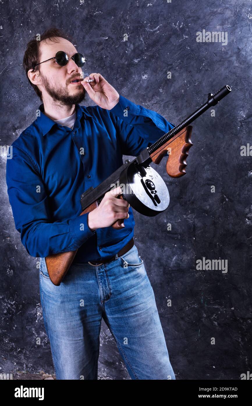 Homme mature en lunettes de soleil avec tommy Gun studio portrait Banque D'Images