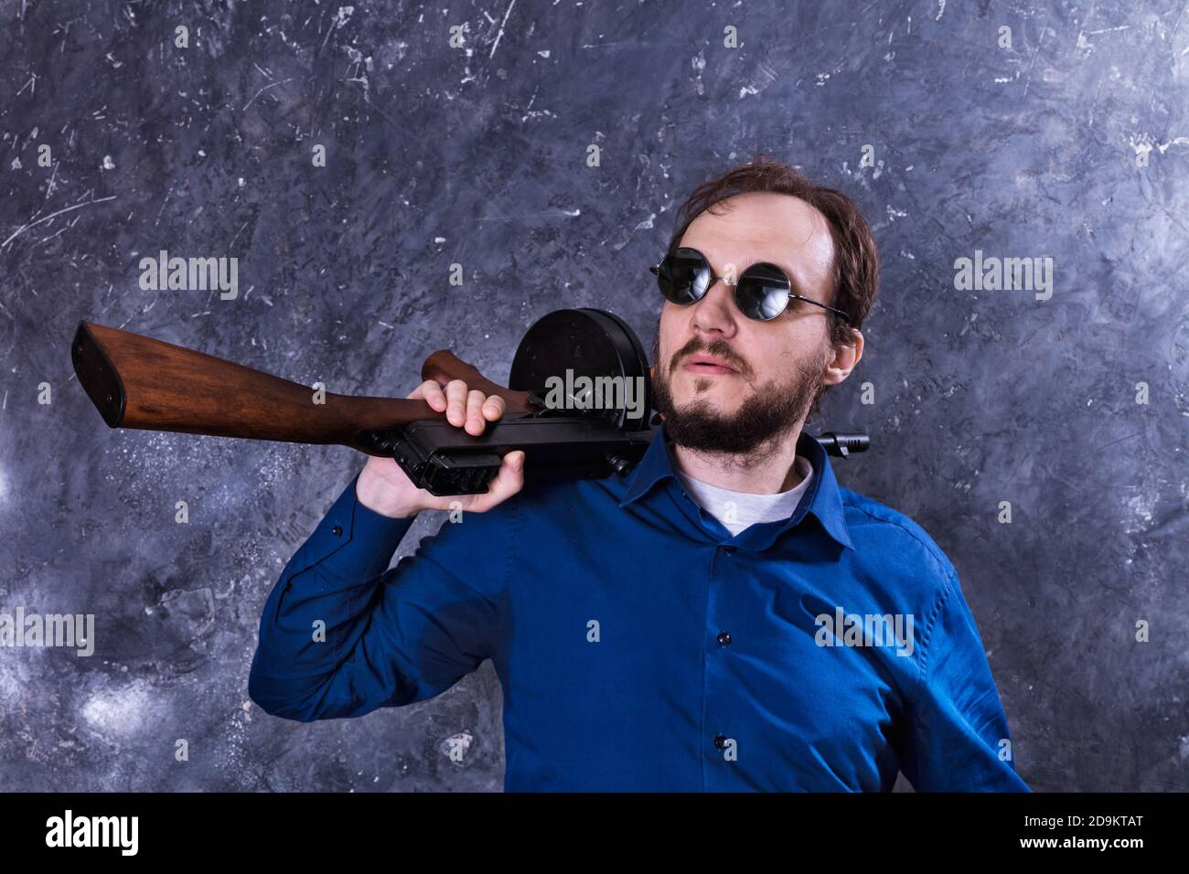 Homme mature en lunettes de soleil avec tommy Gun studio portrait Banque D'Images