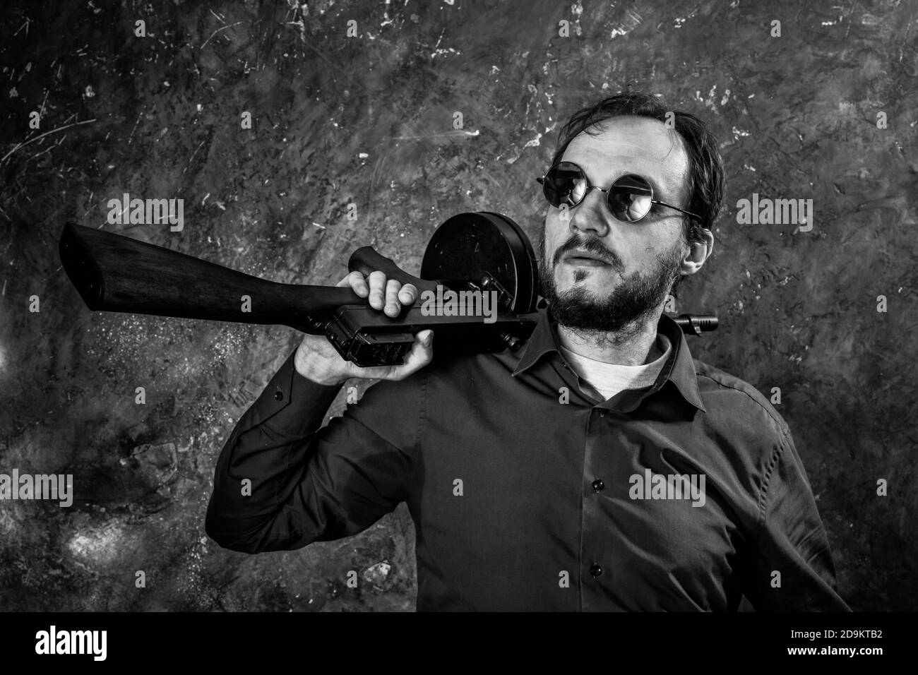 Homme mature en lunettes de soleil avec tommy Gun studio portrait Banque D'Images