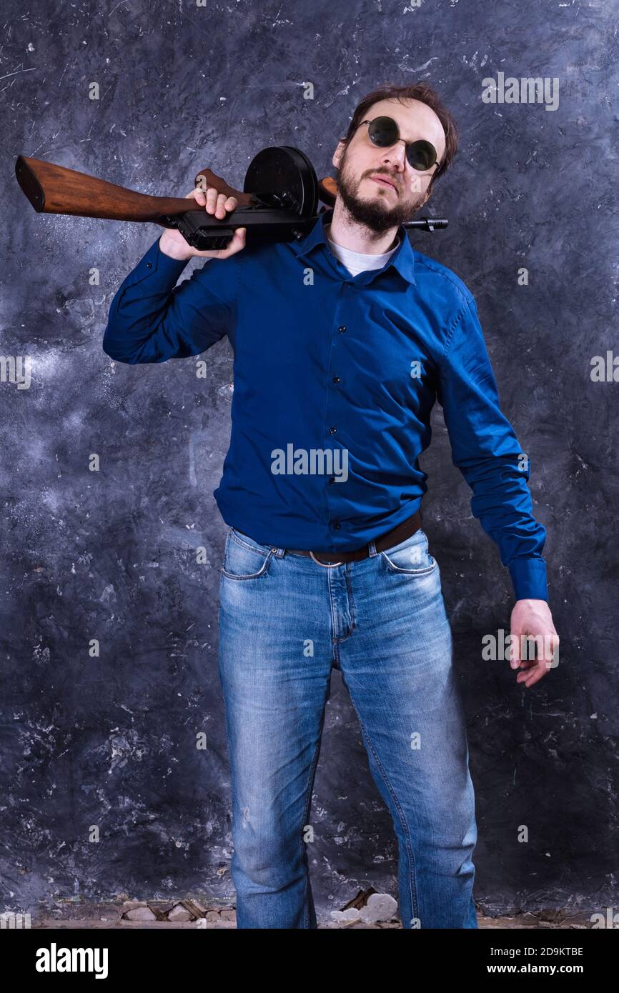 Homme mature en lunettes de soleil avec tommy Gun studio portrait Banque D'Images