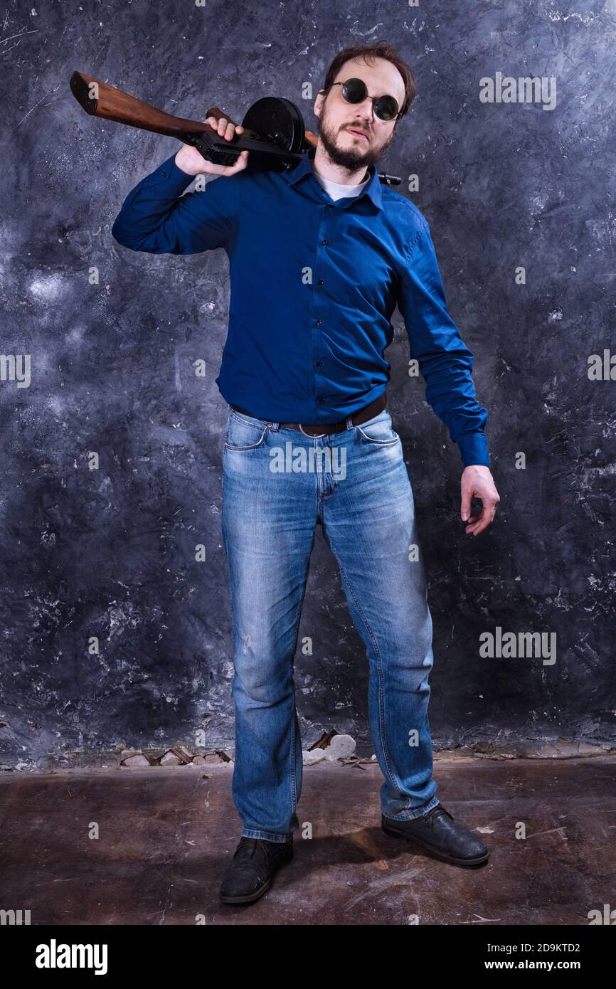 Homme mature en lunettes de soleil avec tommy Gun studio portrait Banque D'Images