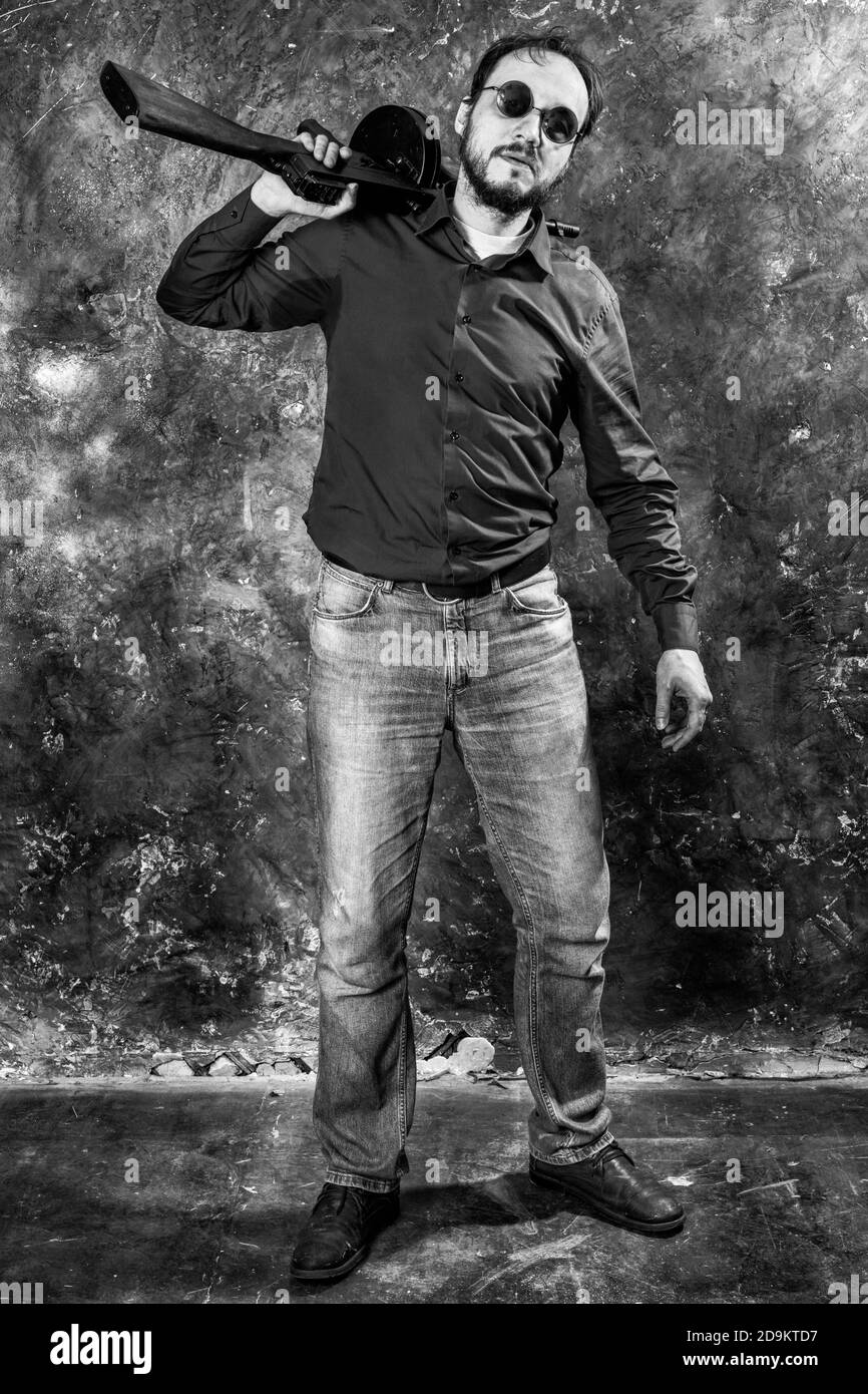 Homme mature en lunettes de soleil avec tommy Gun studio portrait Banque D'Images