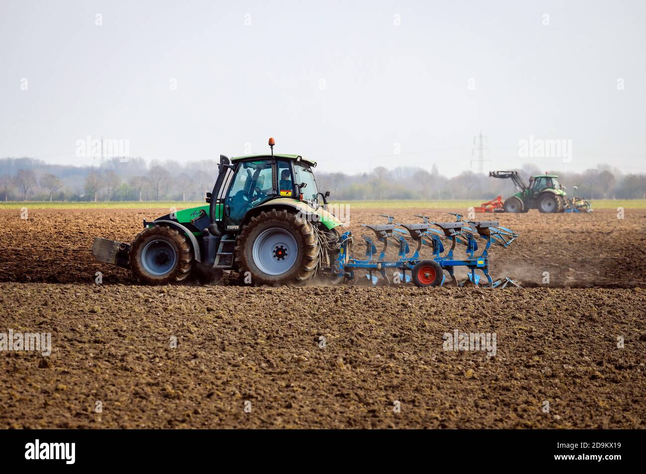 Les tracteurs labourent un champ sec, le préparent pour la culture de légumes, Kempen, Niederrhein, Rhénanie-du-Nord-Westphalie, Allemagne Banque D'Images
