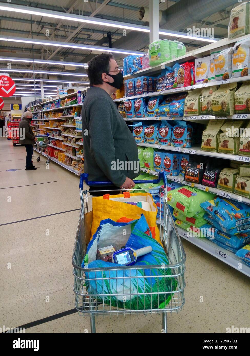 Homme mature portant un masque avec chariot dans un Supermarché du Royaume-Uni Banque D'Images