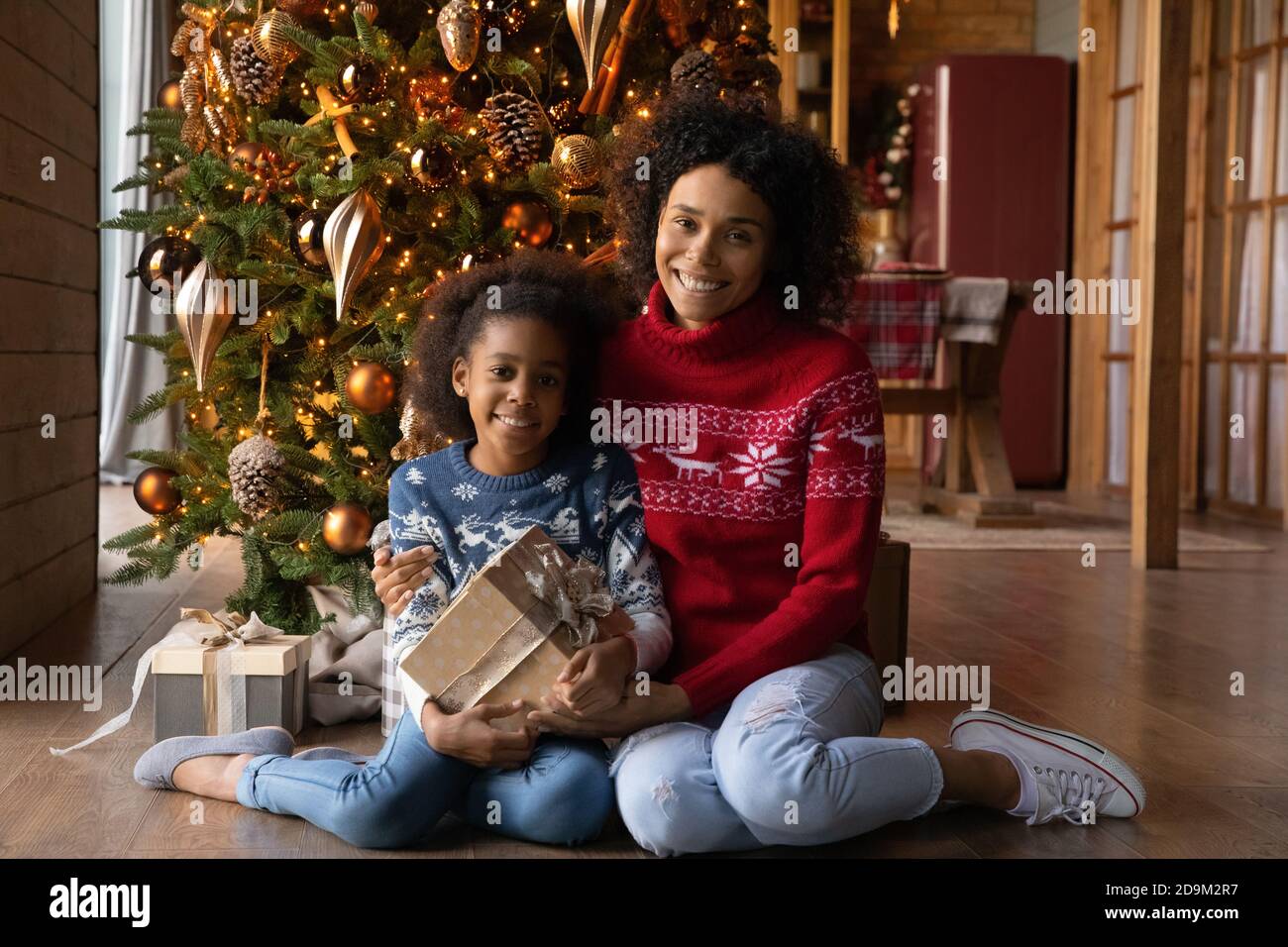 Portrait souriant mère et fille afro-américaine avec cadeau de Noël Banque D'Images