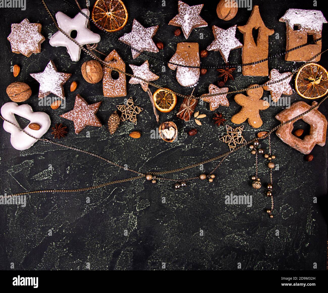 Carte de vœux avec biscuits au pain d'épice, tranches de fruits d'orange séchées, décoration de Noël et du nouvel an sur fond de béton noir. Au-dessus du CH Banque D'Images