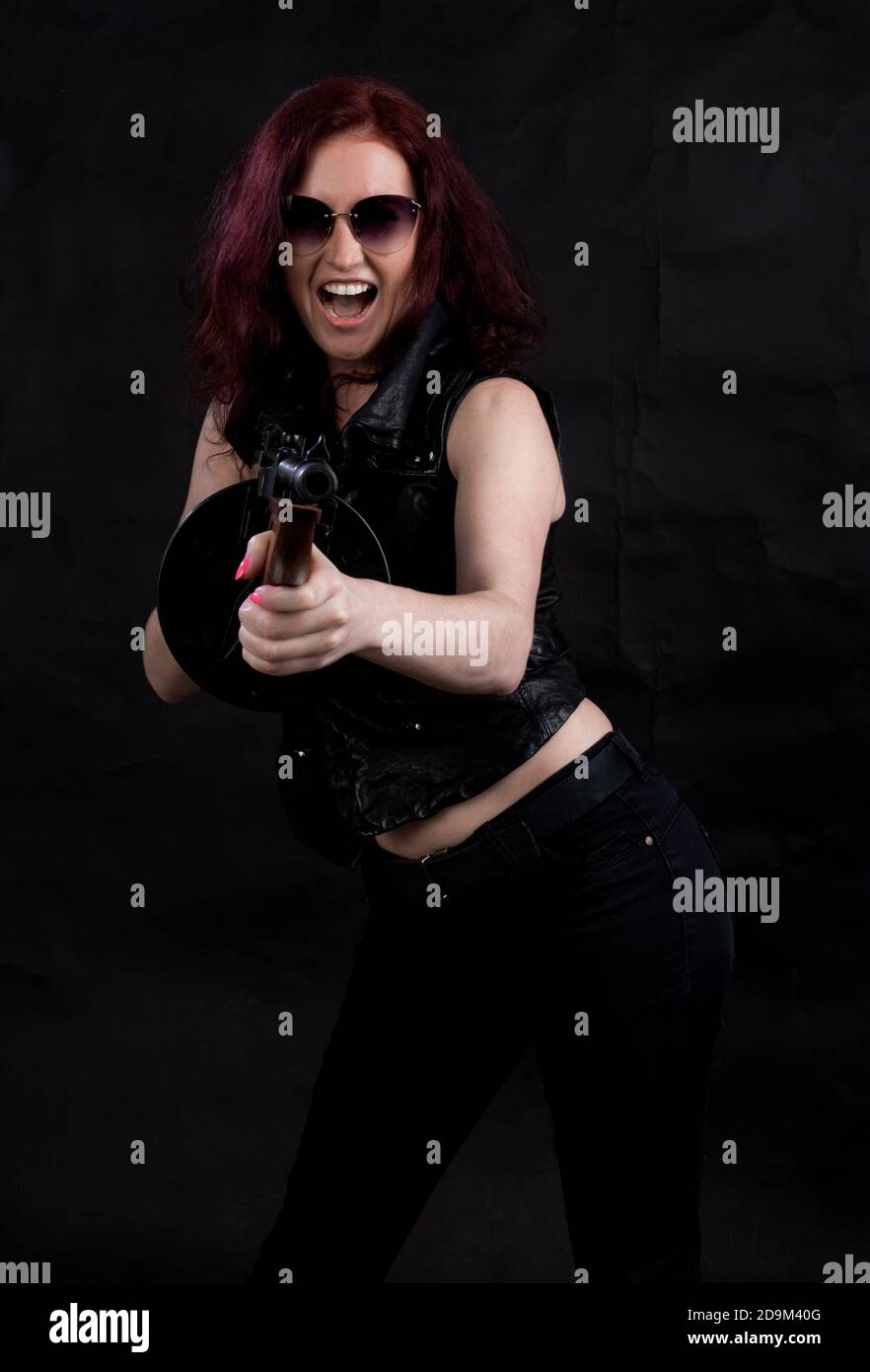 Belle femme vêtue d'une veste noire avec un studio d'armes à feu portrait Banque D'Images