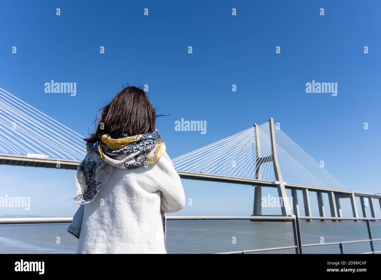 Vue arrière d'une femme se tenant au bord de la rivière pont Banque D'Images