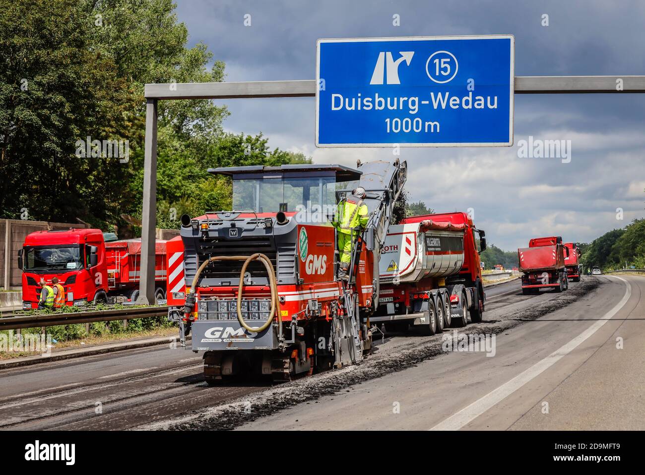 Construction de routes, fraiseuse à froid enlève la vieille couche d'asphalte et charge le camion avec de l'asphalte fraisé, réhabilitation de l'autoroute A3 entre les croix Kaiserberg et Breitscheid, Duisburg, Rhénanie-du-Nord-Westphalie, Allemagne Banque D'Images