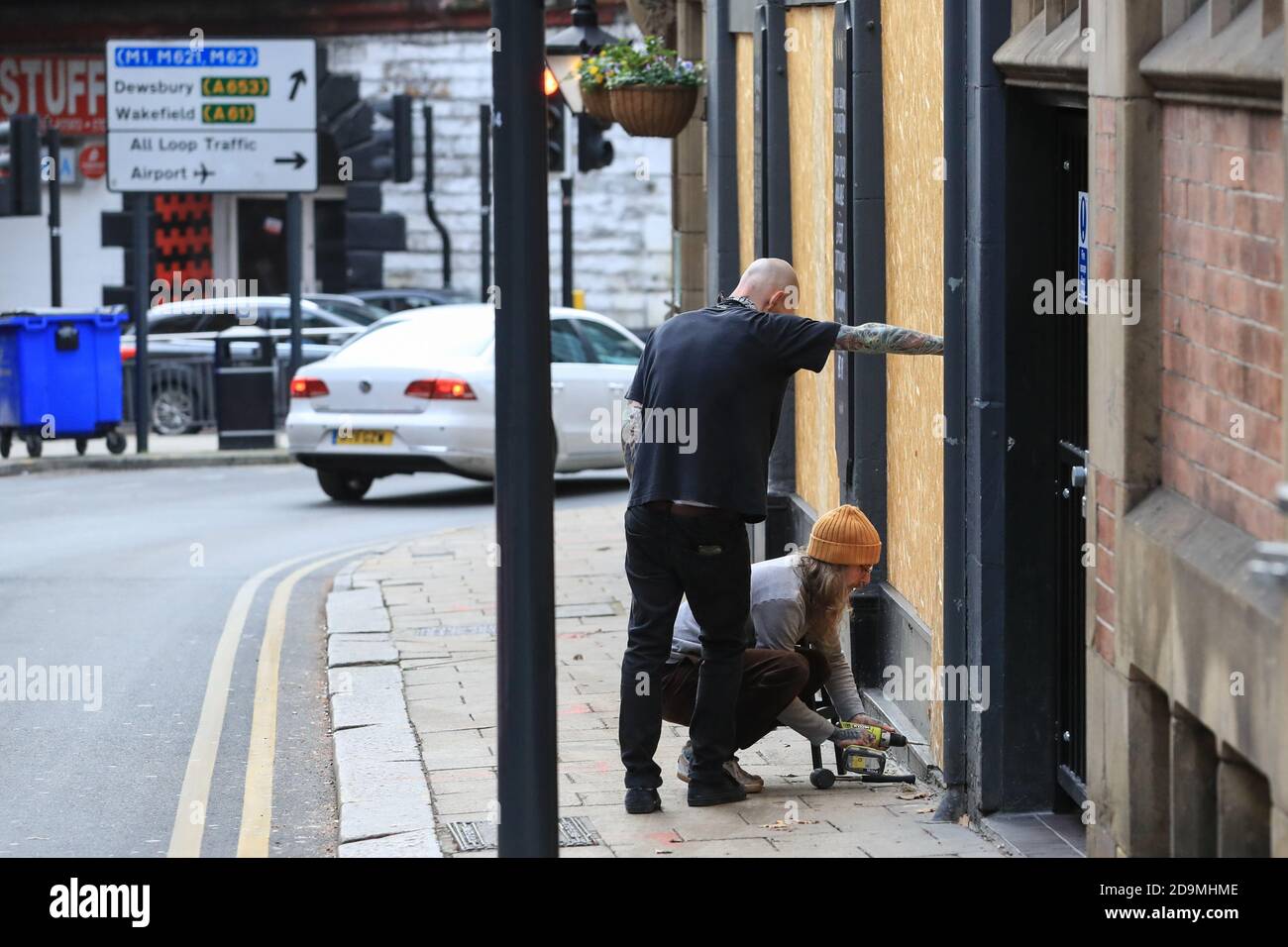 Deux propriétaires de boutiques s'embarquent dans une boutique de tatouage du centre-ville comme le gouvernement les ferme dans le cadre de tier 4 restritcions pendant Covid-19 Premier jour de verrouillage 2 Dans les rues du centre-ville de Leeds Banque D'Images