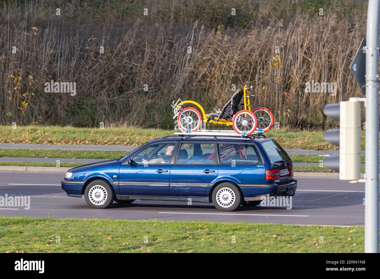 Un tricycle de taille adulte est transporté sur le toit d'une voiture à Wolfsburg. Le vélo sous toutes ses formes est de plus en plus populaire en Allemagne. Banque D'Images