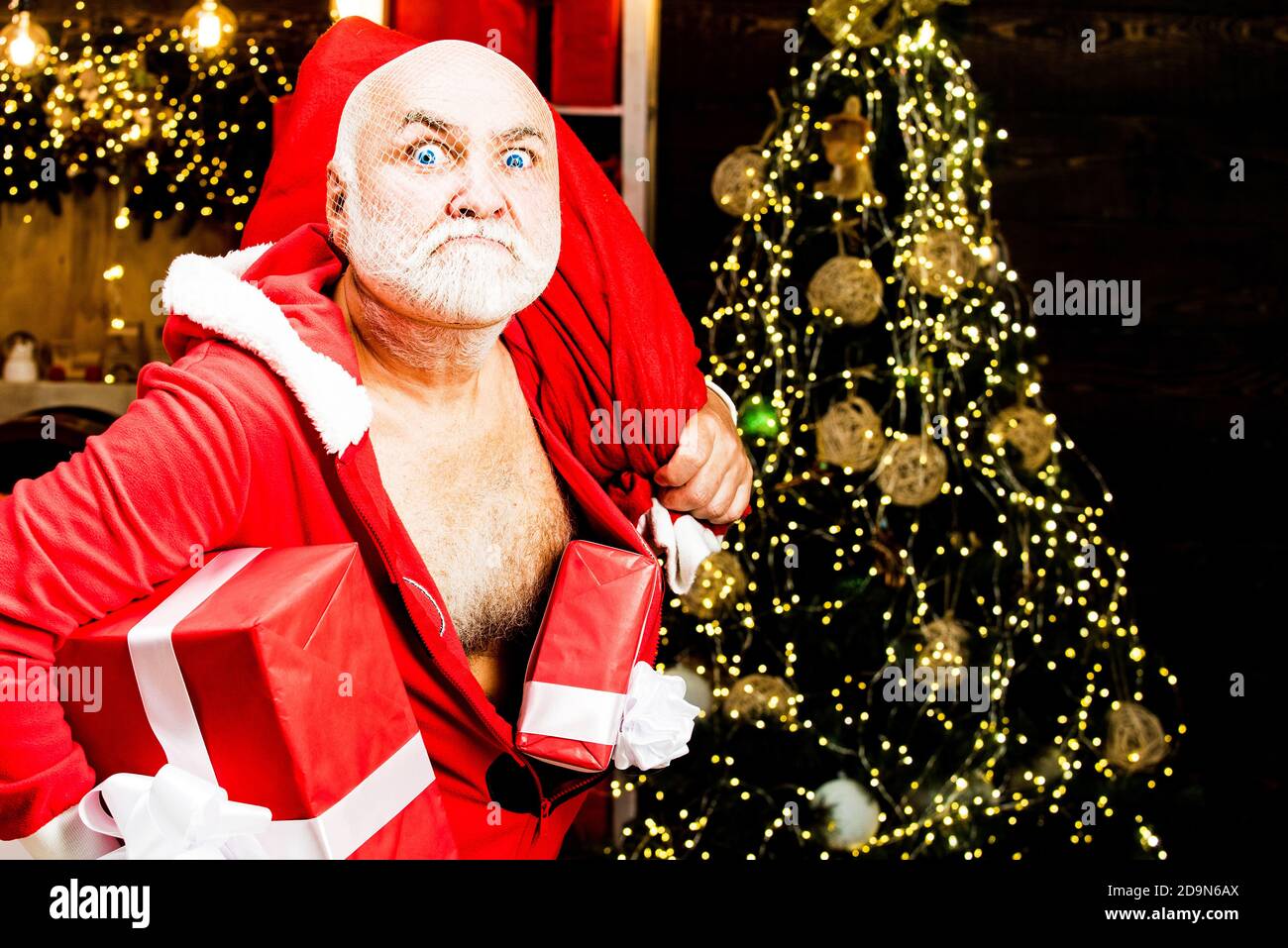 Voleur du Père Noël avec un sac de cadeaux de noël. Home Burglar Santa  Claus dans un masque dans la maison. Meilleurs prix pour les cadeaux  d'hiver. Offre saisonnière Photo Stock -