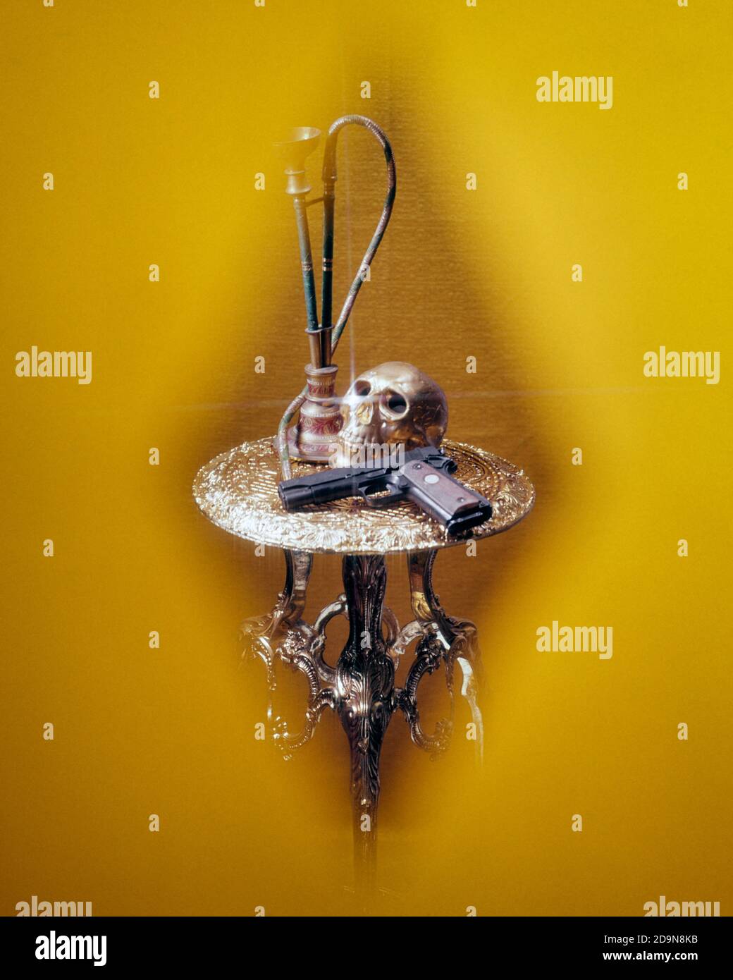 ANNÉES 1970 MYSTÈRE SYMBOLIQUE CRÂNE NARGUILÉ AUTOMATIQUE PISTOLET SUR TABLE EN LAITON VIGNETTE EN FORME DE DIAMANT SUR FOND OR - KS10359 PHT001 HARS AUTOMATIQUE COMPOSITE ORNÉ 45 MÉTIERS DANGEREUX ÉPILE DANGER DANGEREUX CONCEPT NOIR CONCEPTUEL ENCORE LA VIE ÉCHAPPER ESPIONNAGE FELONY HOOKAH DANGER LE CALIBRE SYMBOLIQUE COLT CONCEPTS ARMES À FEU ARME À FEU PISTOLET TUYAU D'EAU ILLÉGAL VIGNETTE EXOTIQUE INTERNATIONALE DE REPRÉSENTATION À L'ANCIENNE DU MOYEN-ORIENT Banque D'Images