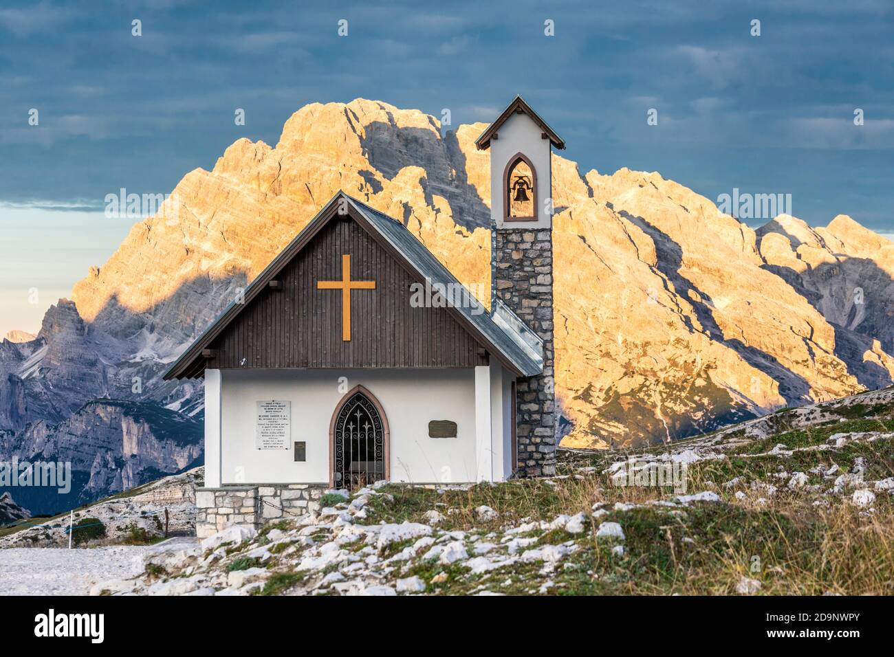 Chapelle de l'Alpini (Cappella degli Alpini) au pied de la Tre Cime di Lavaredo, en arrière-plan le mont Cristallo embrassé par le soleil, les Dolomites, Auronzo di Cadore, province de Belluno, Vénétie, Italie, Europe Banque D'Images