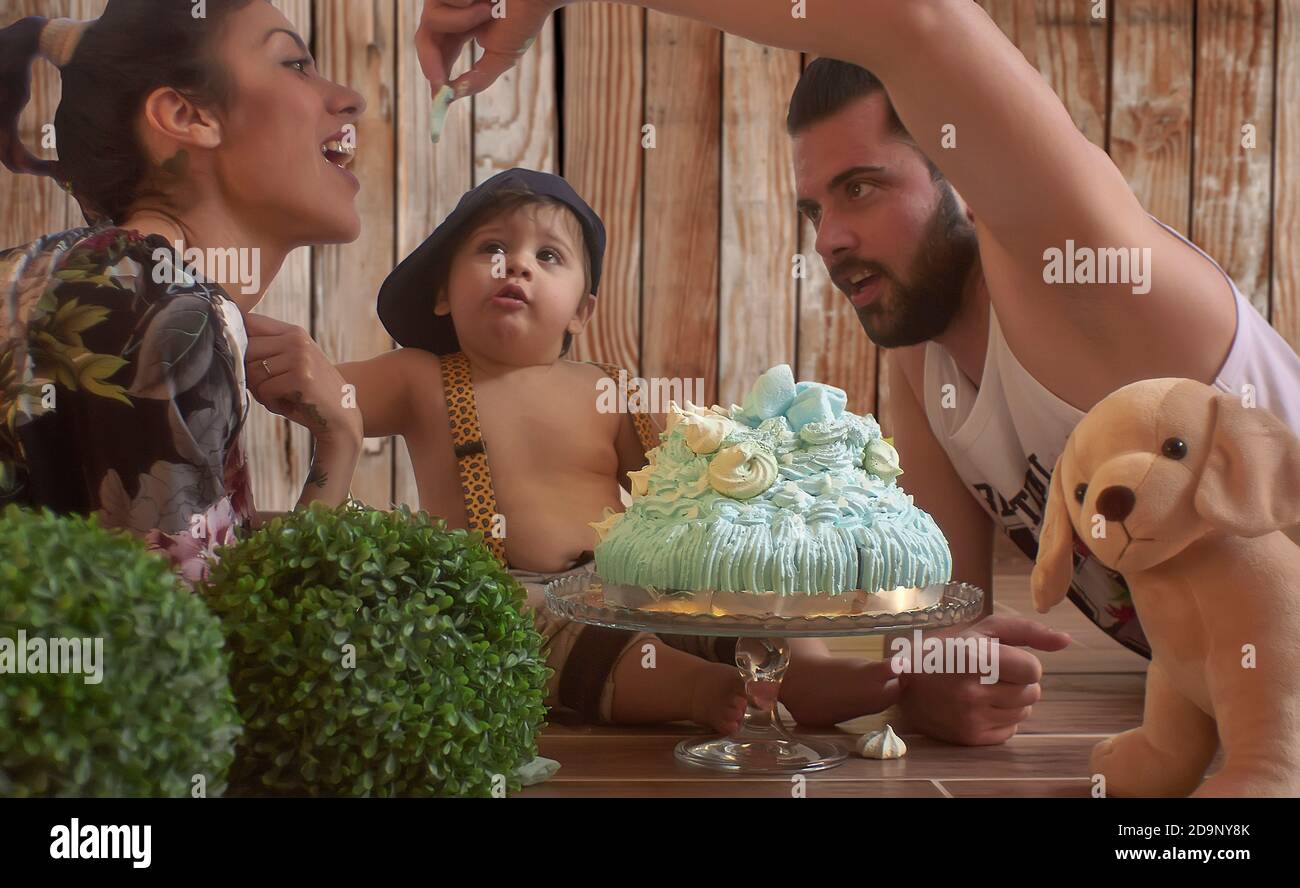 Bebe Avec Gateau D Anniversaire Dans Un Ensemble Photographique Avec Maman Et Papa Photo Stock Alamy