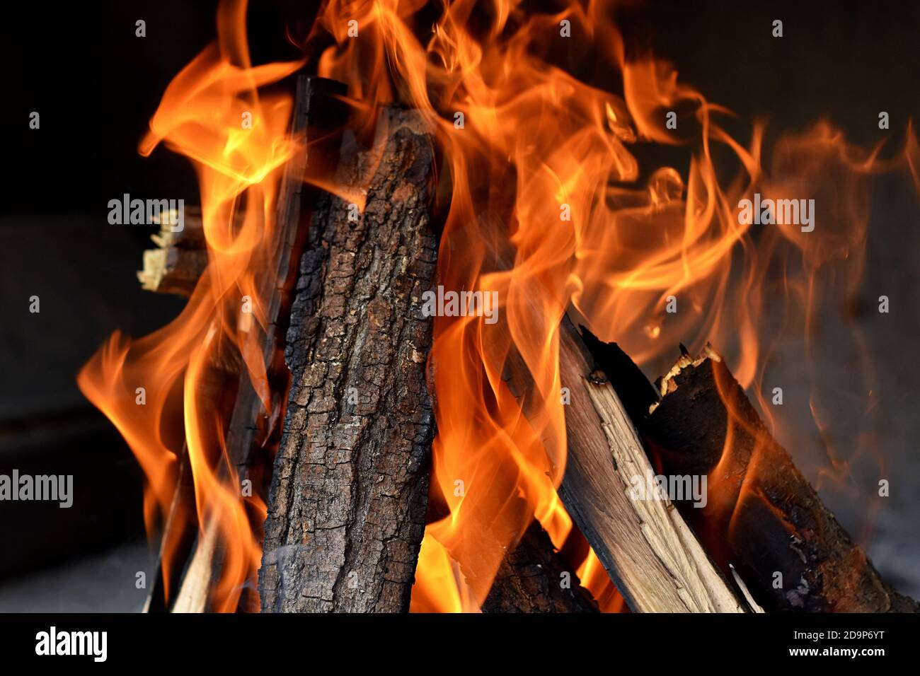 Tirer des flammes avec des étincelles sur fond noir, UN feu brûle dans une cheminée, un feu pour garder au chaud Banque D'Images