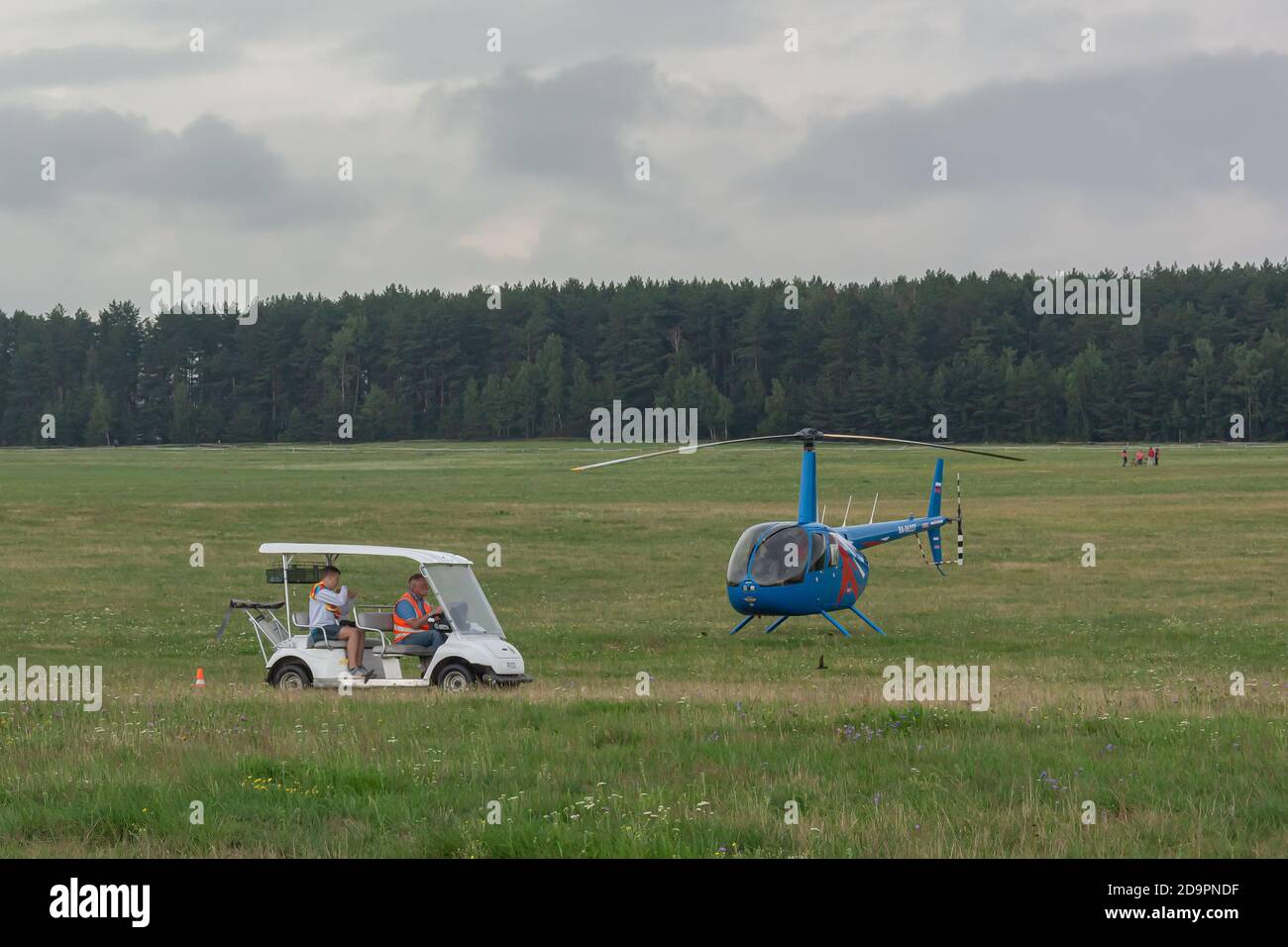 Bélarus, Minsk - 07/25/2018: Voiture électrique et hélicoptère à deux places sur le champ vert de l'aérodrome. Photos Banque D'Images