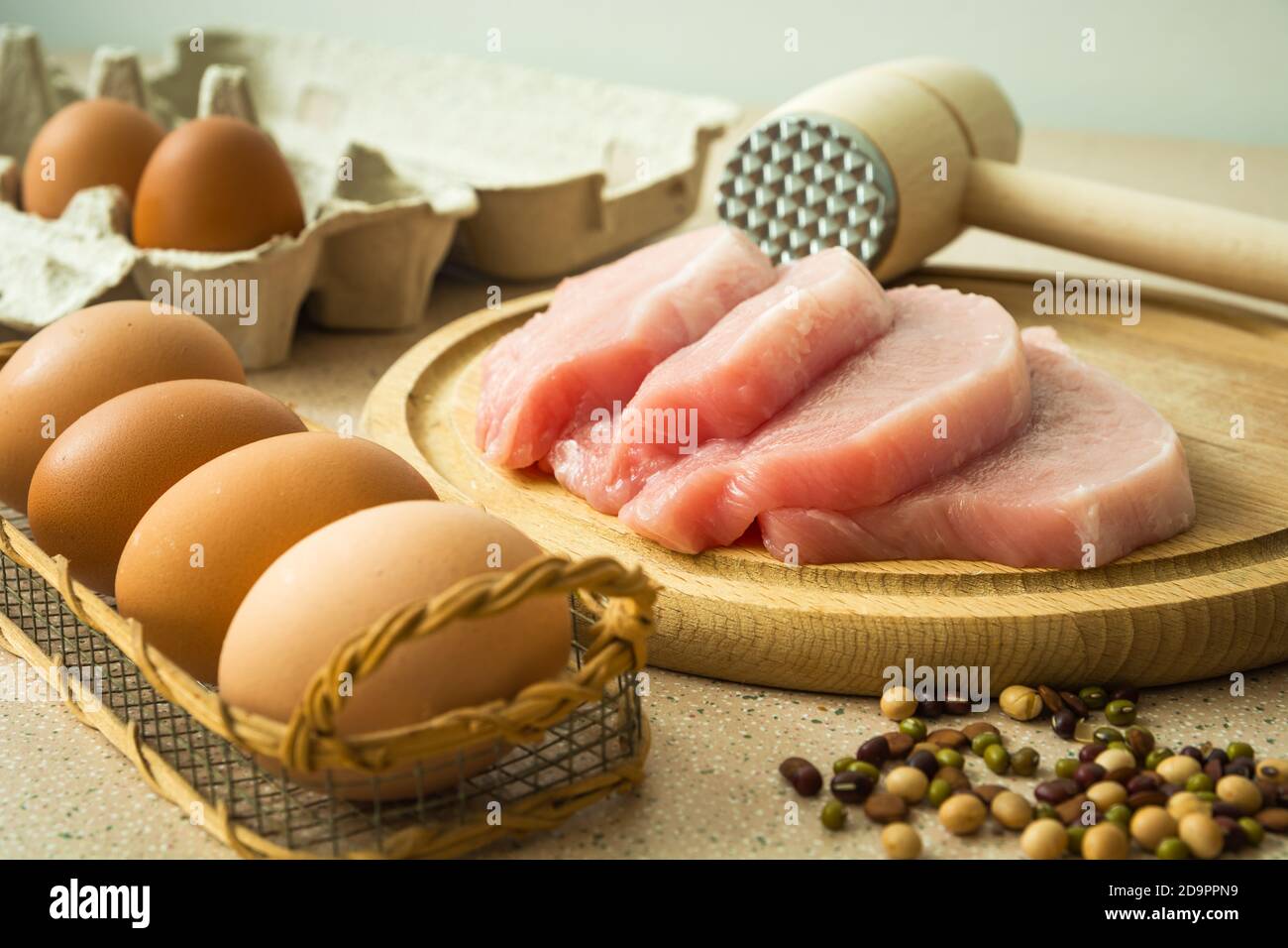 Viande de longe crue sur une planche, un maillet de viande et des œufs Banque D'Images