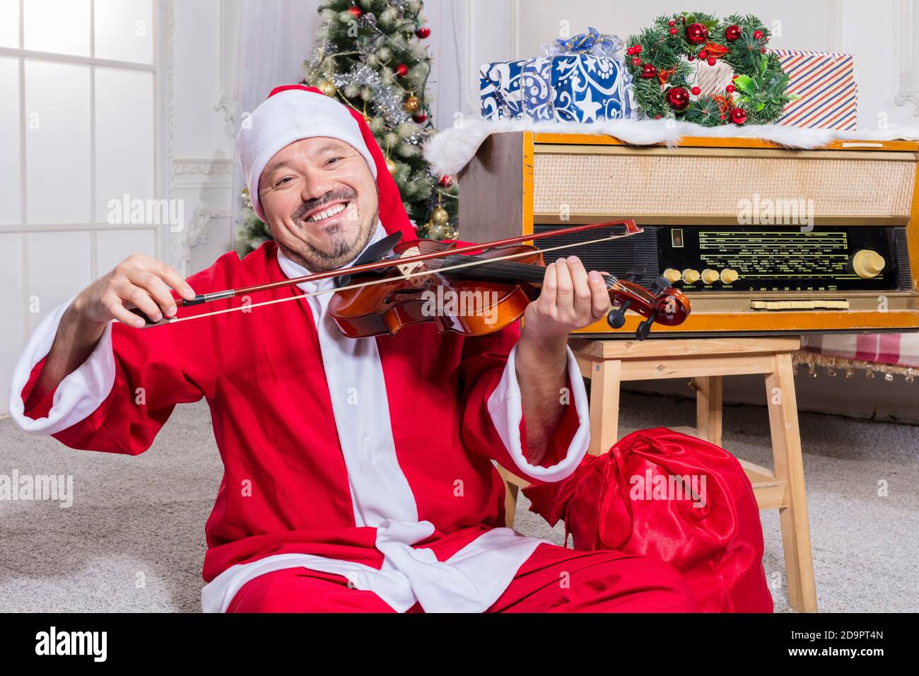 Homme barbu vêtu d'un costume de Père Noël jouant au studio de violons portrait Banque D'Images