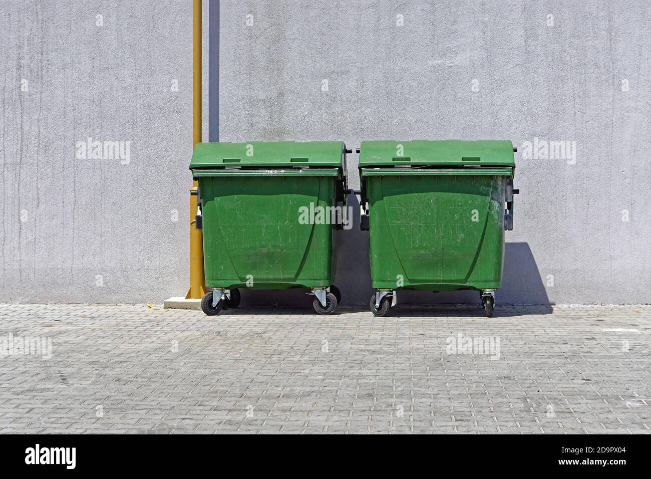 Deux bacs de recyclage verts avec conteneurs à roulettes Banque D'Images