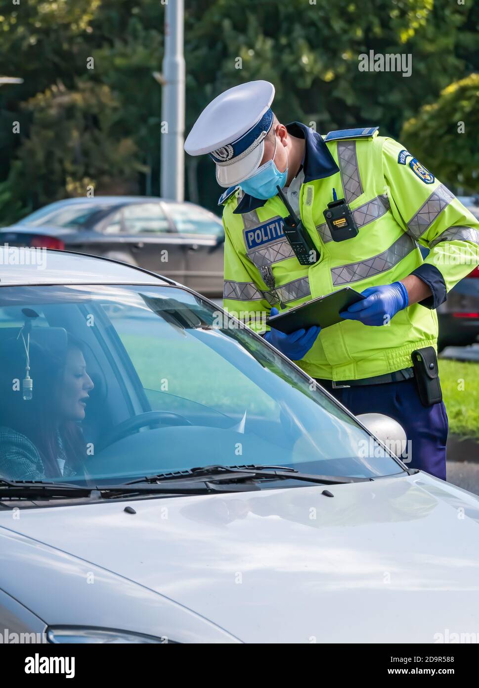 Bucarest/Roumanie - un agent de police de la circulation rédige un billet pour une femme qui a enfreint la loi. Banque D'Images