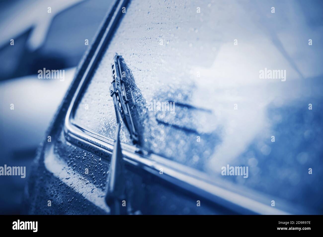 La lunette arrière de la voiture et l'essuie-glace noir étaient humides par forte pluie. Mauvais temps. Gouttes de pluie. Banque D'Images