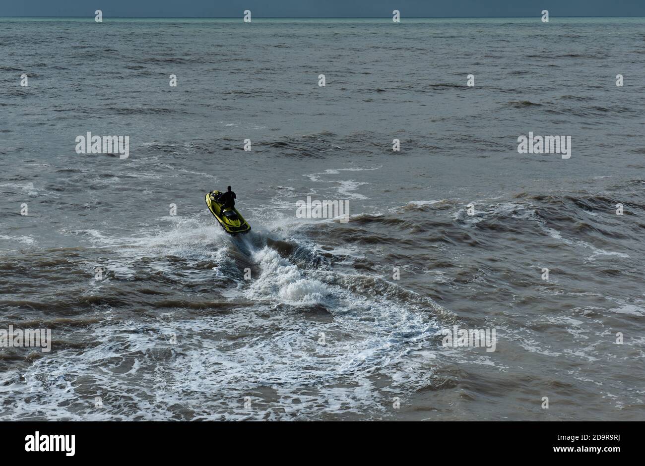 Homme actif qui fait du scooter des mers avec un saut, Brighton, Angleterre Banque D'Images
