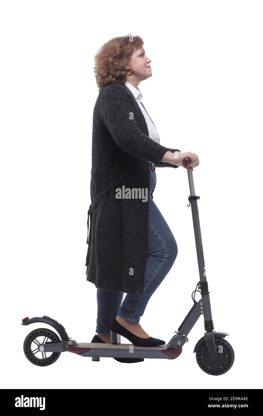 vue latérale. femme confiante avec un scooter électrique regardant la caméra Banque D'Images