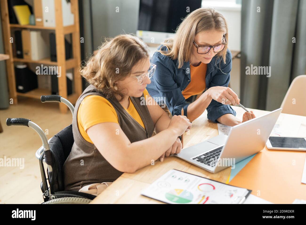 Deux jeunes femmes cadres ou courtiers sérieux lisant des données sur écran d'ordinateur portable Banque D'Images