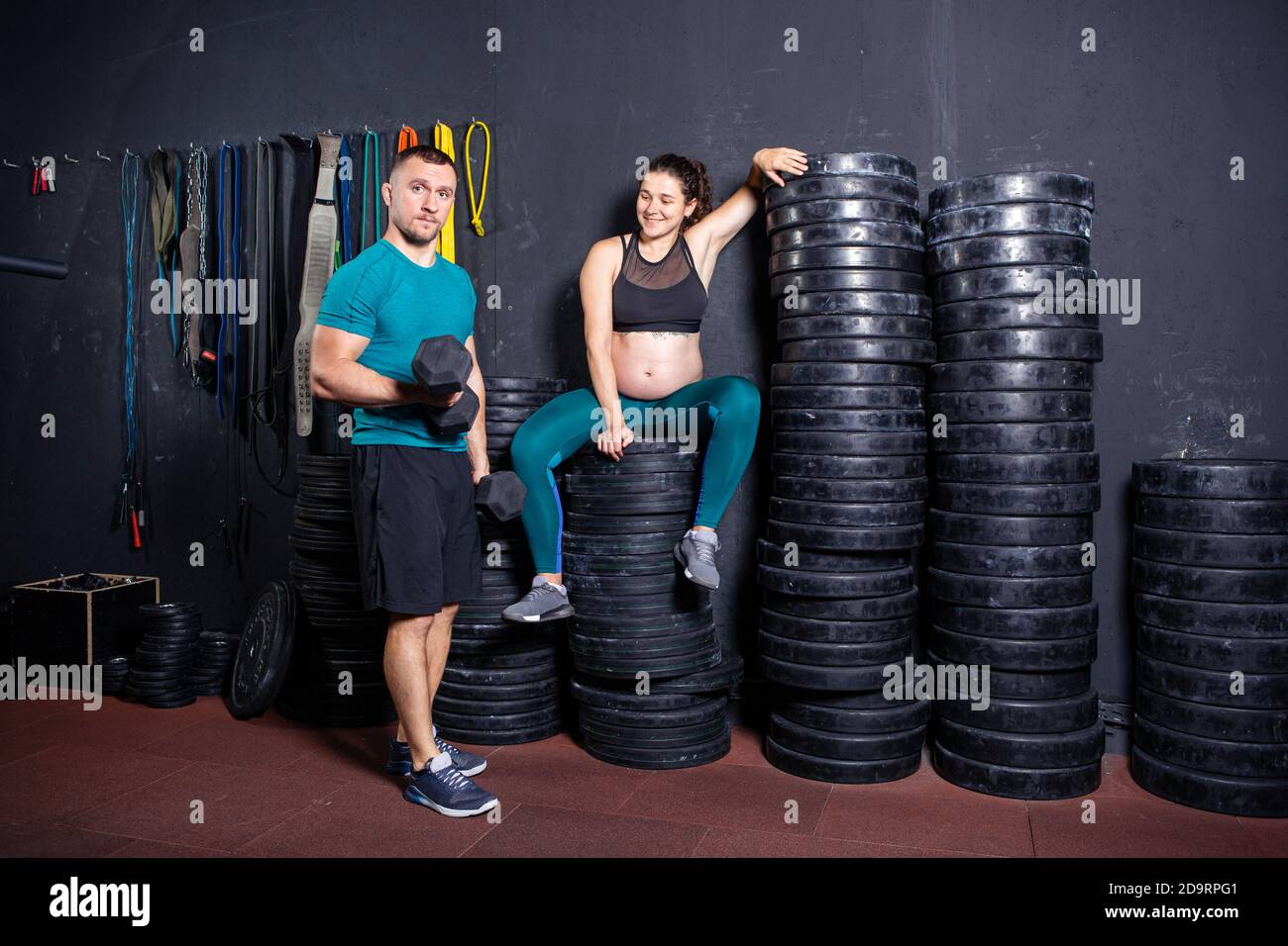 Athlètes femme enceinte et son mari posant dans la salle de gym près de  l'équipement sportif. Grossesse sportive active. Faites de l'exercice dans  la salle de sport pendant Photo Stock - Alamy