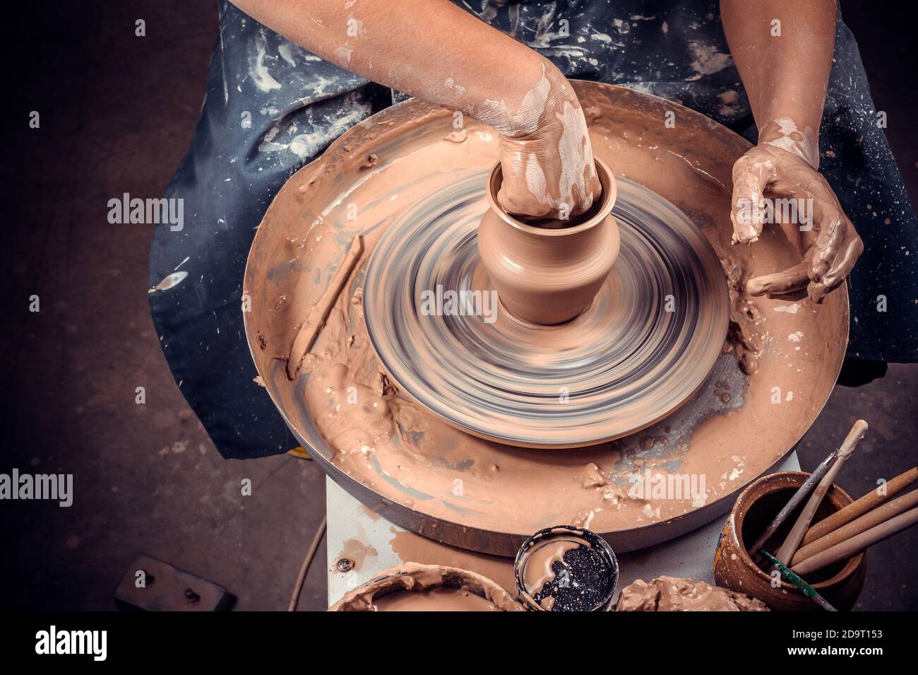 Gros plan des mains de potter avec le produit sur un potter roue Banque D'Images