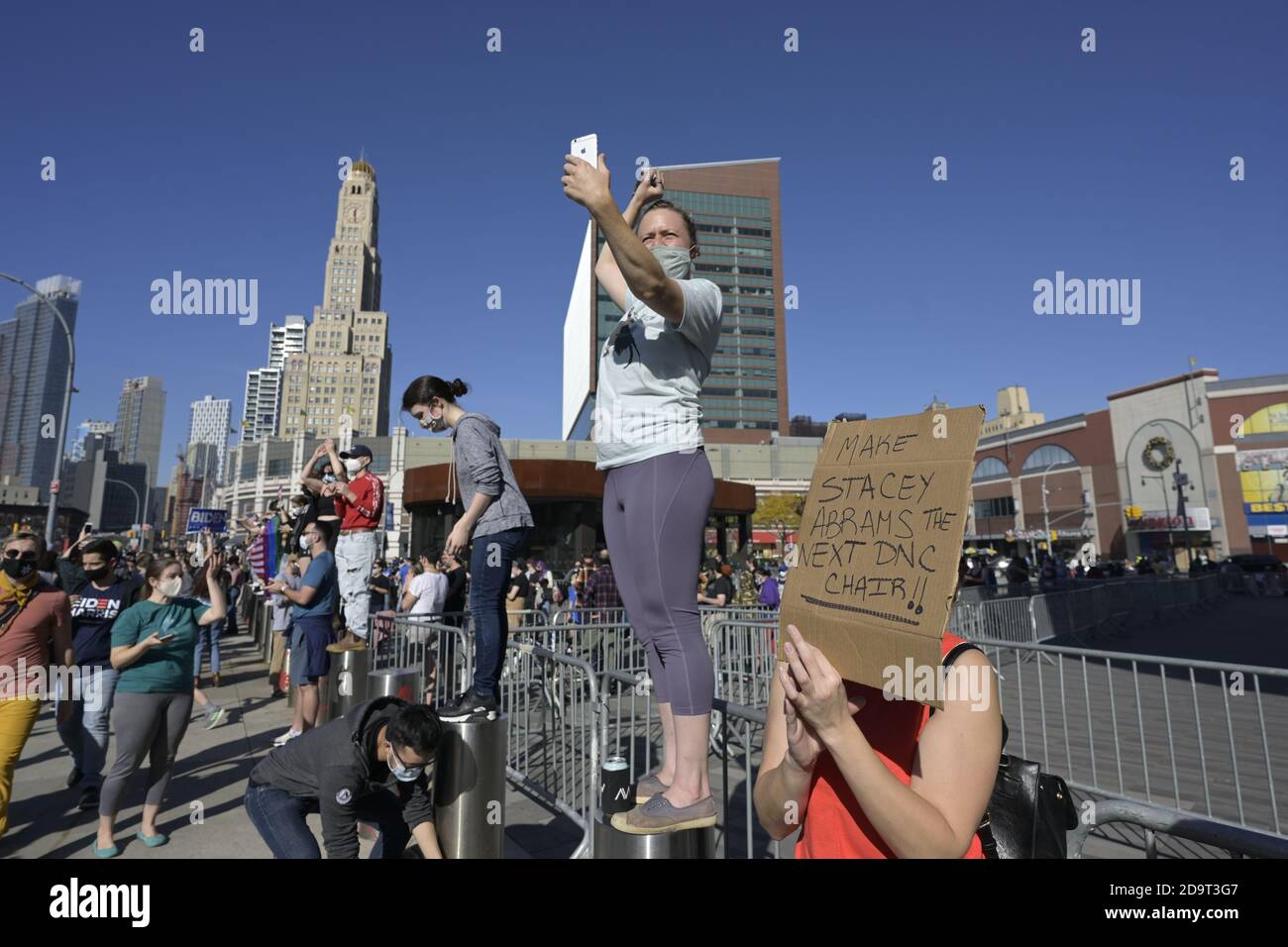 Brooklyn, New York, États-Unis 7 novembre 2020. Une femme porte un panneau pro-Stacey Abrams tandis que les gens à l'extérieur du Barclays Center à Donwtown Brooklyn célèbrent la victoire projetée de Joe Biden dans la course présidentielle américaine Banque D'Images