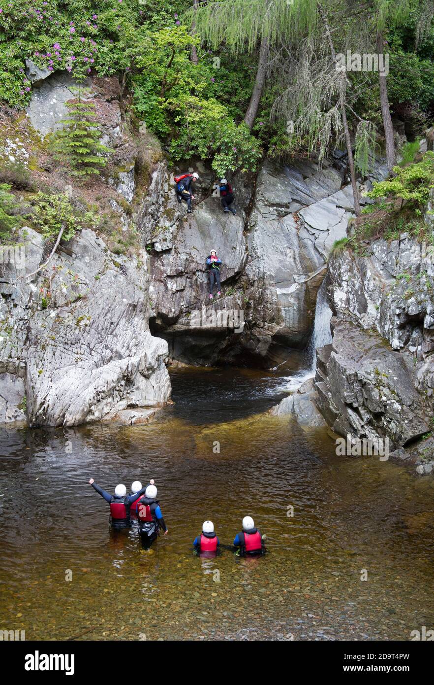 Des gens descendant la roche et dans une piscine sous les chutes de Bruar, dans le Perthshire, en Écosse, au Royaume-Uni. Banque D'Images