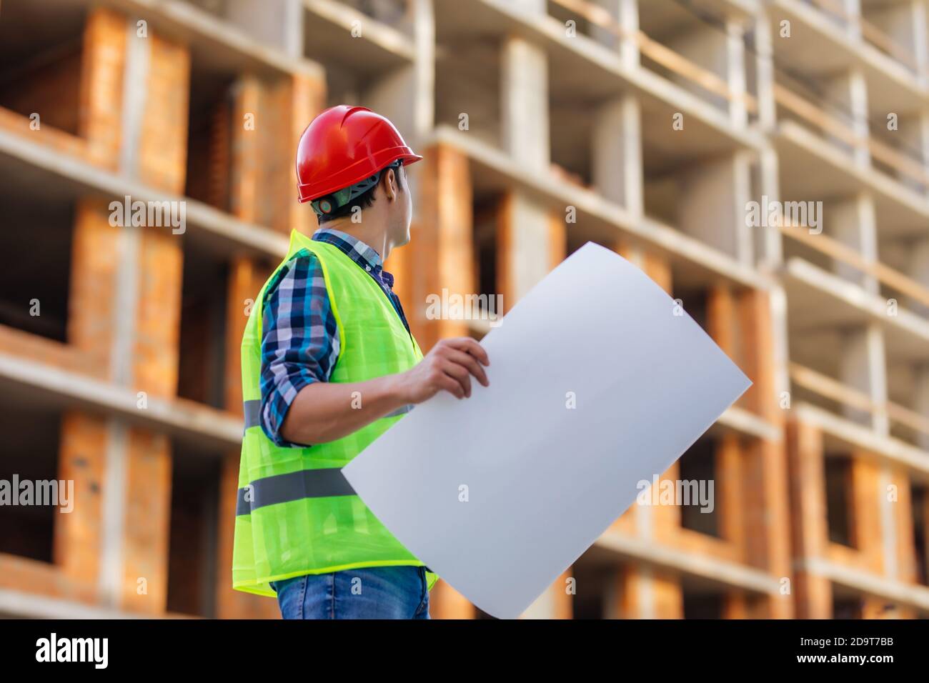 Gros plan des ingénieurs travaillant sur un chantier de construction tenant un modèles Banque D'Images