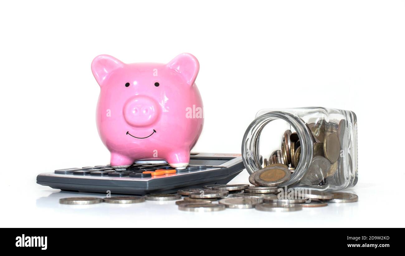 Une pièce sort d'une bouteille d'argent et d'une banque de porc sur une calculatrice sur fond blanc concept de dépenser et d'économiser de l'argent. Banque D'Images