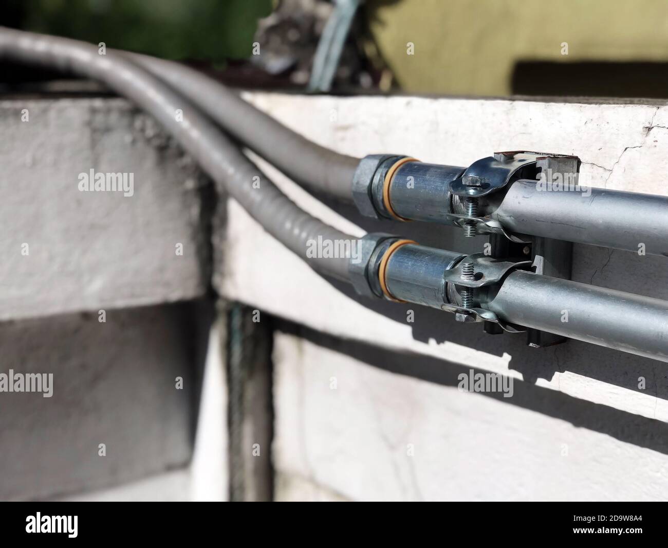 Fermer les tuyaux en acier pour les fils électriques externes installés sur le mur. Banque D'Images