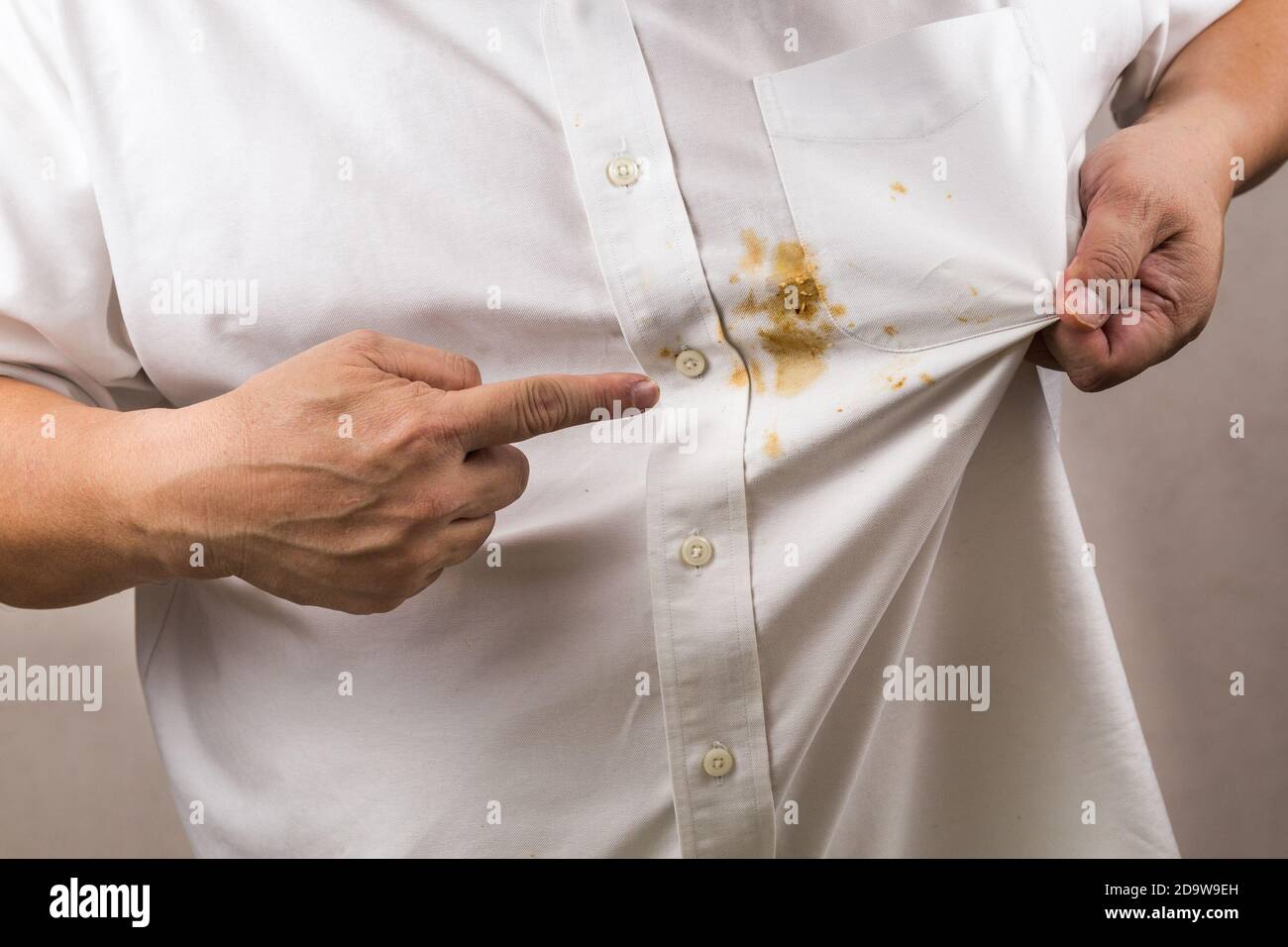 Personne pointant vers une tache de curry renversée sur une chemise blanche  Photo Stock - Alamy