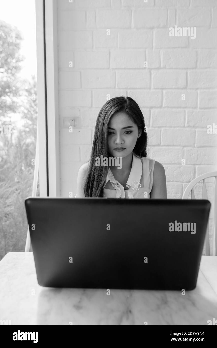 Jeune femme asiatique magnifique utilisant un ordinateur portable Banque D'Images