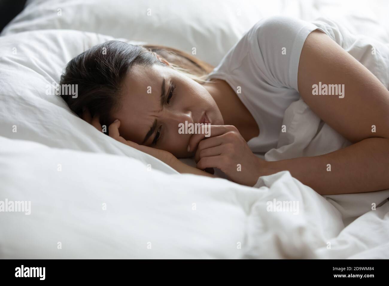 Une femme en dépression qui s'est couchée au lit passe la nuit seule Banque D'Images