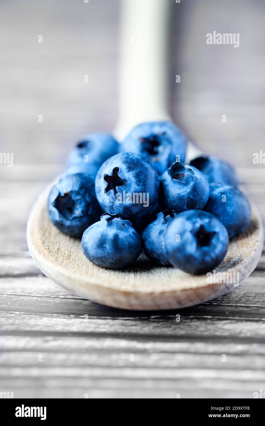 Frais, bleuets, Cyanococcus, sur une cuillère en bois. Le bleuet est une source riche d'antioxydants et riche en vitamines c et K. Banque D'Images Frais, bleuets, Cyanococcus, sur une cuillère en bois. Le bleuet est une source riche d'antioxydants et riche en vitamines c et K. Banque D'Images