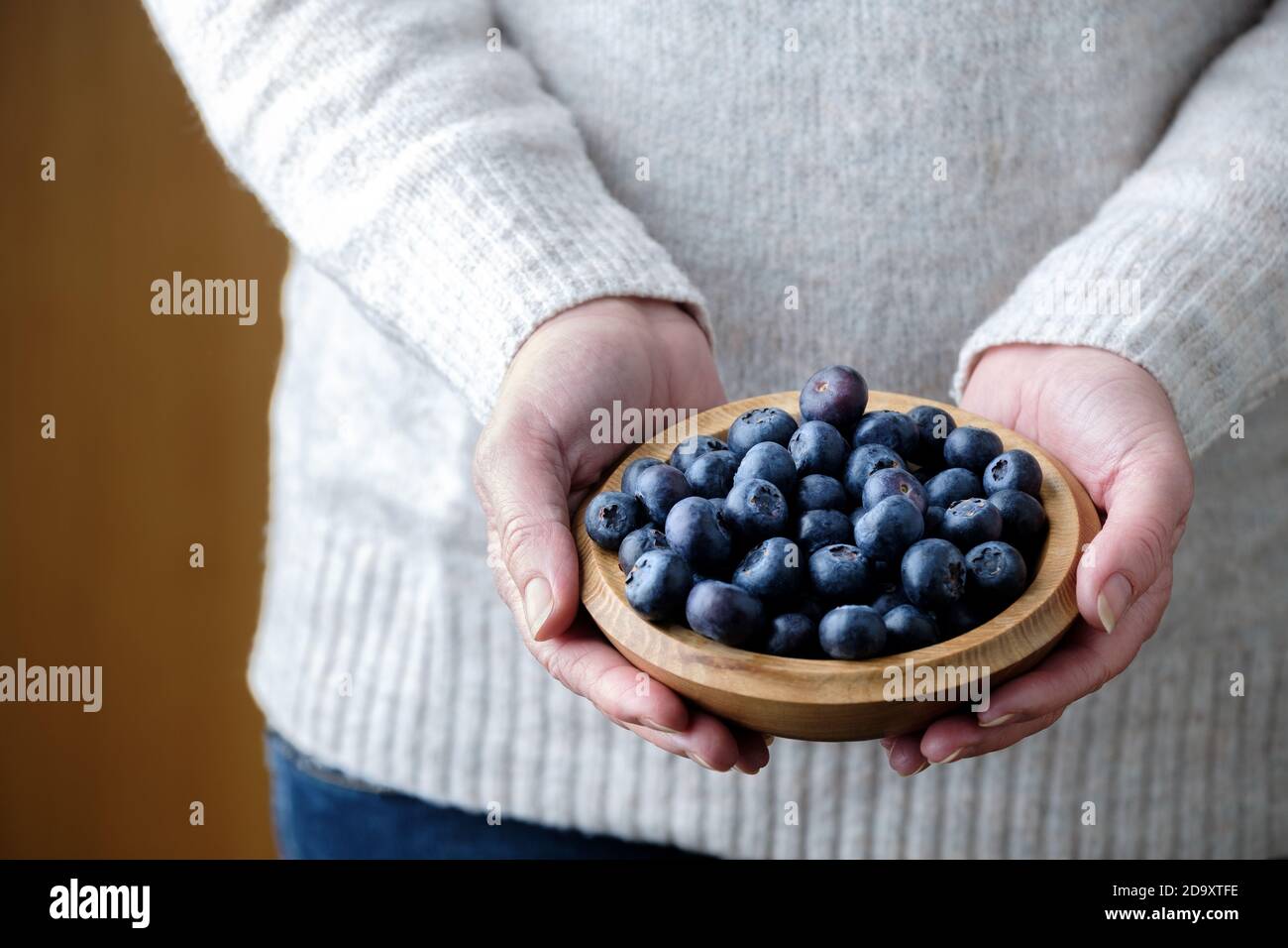 Une femme tenant un bol en bois de bleuets frais, Cyanococcus. Le bleuet est une source riche d'antioxydants et riche en vitamines c et K. Banque D'Images Une femme tenant un bol en bois de bleuets frais, Cyanococcus. Le bleuet est une source riche d'antioxydants et riche en vitamines c et K. Banque D'Images