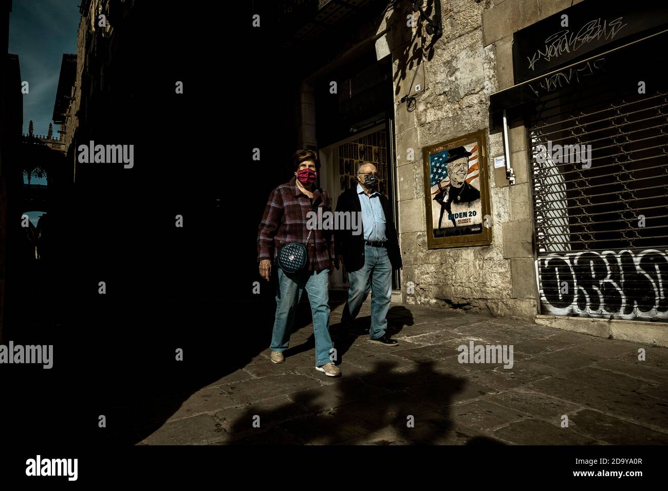 Barcelone, Espagne. 8 novembre 2020. Un couple passe devant un graffiti de l'artiste urbain italien 'TVBoy', Salvatore Benintende, intitulé 'si je peux changer et vous pouvez changer, tout le monde peut changer', représentant le président américain élu Joe Biden après le tournant dans les élections américaines de 2020 crédit: Matthias Oesterle/Alamy Live News Banque D'Images